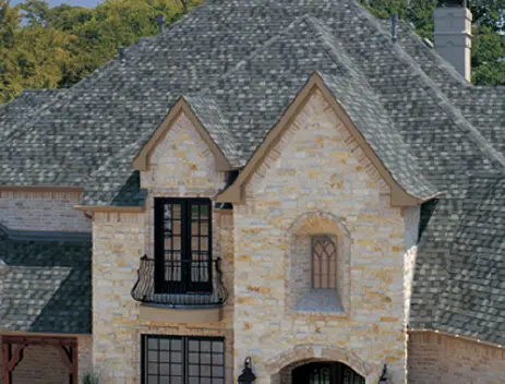 A large stone house with two windows and a balcony.